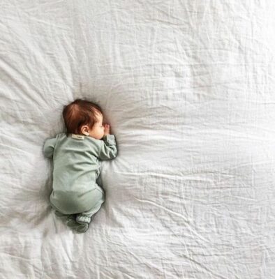 baby sleeping on soft bed